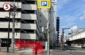 信号を渡り左折します。立体駐車場の「P」マークが目印です。